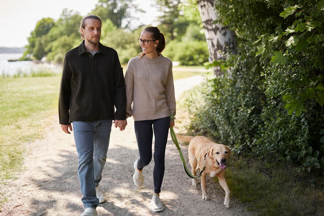 En man och en kvinna är ute och går med en hund.