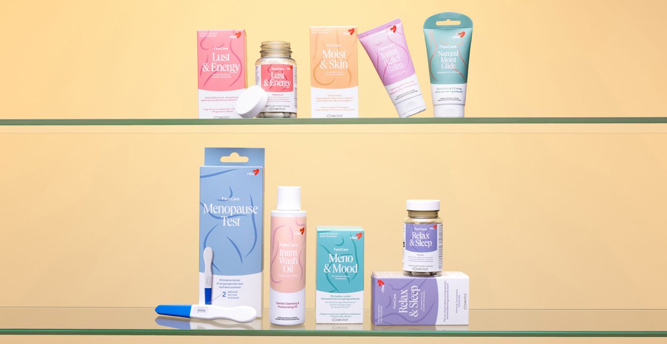 Produkter från RFSU FemCare står uppradade på ett bord mot en gul bakgrund.